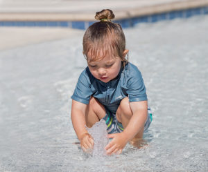 Young girl interacting with Underwater Bubbler ground spray