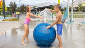 Harvey Park splash pad - two children playing with a custom water globe