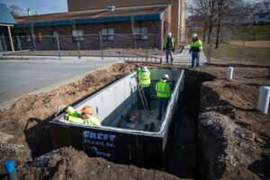 workers installing the MecH2O, a simplified water delivery system for splash pads