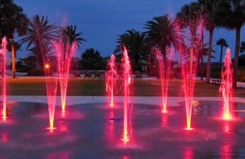 Wide shot of Jekyll Island splash pad at night with pink LED lights