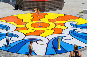 Wide shot of Tanger Outlets splash pad showing colorful play surfacing