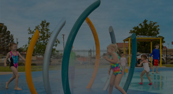 Children running through misting ribs at a water park