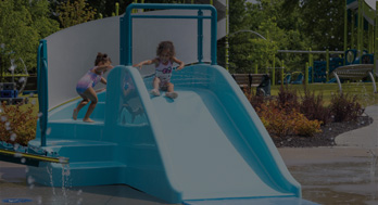 child about to slide down a water slide at a splash park