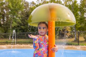 A child's hands circle around a bubbling ground spray