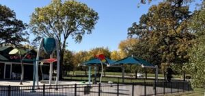 Splash pad in the off-season surrounded by trees beginning to turn autumn colors